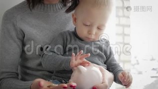母亲和小儿子把硬币放进储蓄罐里，以备将来储蓄。mp4格式视频下载_正版视频编号3323874-摄图网