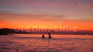 在美丽的夕阳下，父亲和小儿子在海里洗澡，用手缓慢地挥动着mp4格式视频下载_正版视频编号3098983-摄图网