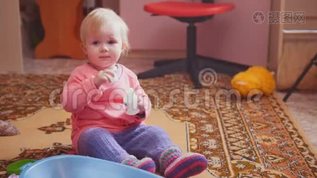 可爱的小女孩在玩她的玩具，微笑着，坐在地板上mov格式视频下载_正版视频编号1975444-摄图网