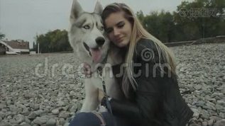 一可爱的女人，带着西伯利亚哈士奇狗坐在海岸上mov格式视频下载_正版视频编号1382422-摄图网