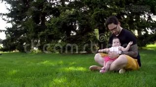 爸爸和女儿坐在草地上，给她看远处的东西mov格式视频下载_正版视频编号3034692-摄图网