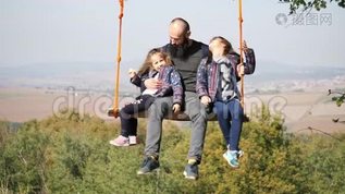爸爸和女儿在树下荡秋千。mov格式视频下载_正版视频编号3114235-摄图网