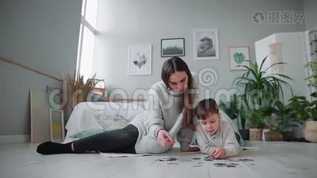 妈妈带着一个孩子在他家白色的内部和他的小儿子一起收集拼图。 快乐mov格式视频下载_正版视频编号2746283-摄图网