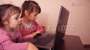 孩子们在笔记本电脑里玩。 两个小女孩印在笔记本电脑上。 两个姐姐坐在橙色的沙发上看着一圈mov格式视频下载_正版视频编号2232252-摄图网