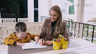 母亲和年幼的儿子在餐桌旁画画mov格式视频下载_正版视频编号578630-摄图网
