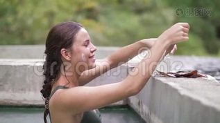 快乐的女人洗热水澡，收集面膜的愈合泥。 年轻女子享受天然温泉mov格式视频下载_正版视频编号1936933-摄图网