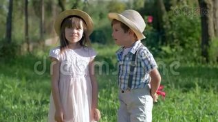 童年时，孩子们在耳边低语着一个可爱的小女孩的秘密，在夏天的公园里给她一朵花mp4格式视频下载_正版视频编号3065220-摄图网 