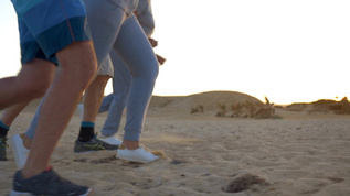 在海滩上四个人进行跑步比赛他们的腿部特写视频素材