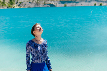 女人放松在海滩上享受阳光的照耀，闭着眼睛，旅行愉快夏天概念，水