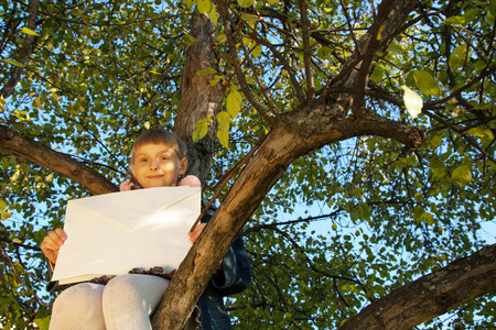 美丽的姑娘坐在树上读信