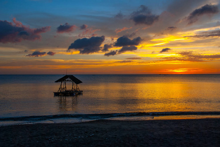 在海滩上美丽的夕阳。亭子的剪影。香兰，班乃菲律宾