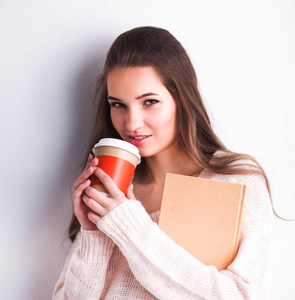 肖像杯茶或咖啡，一名年轻女子拿着本书