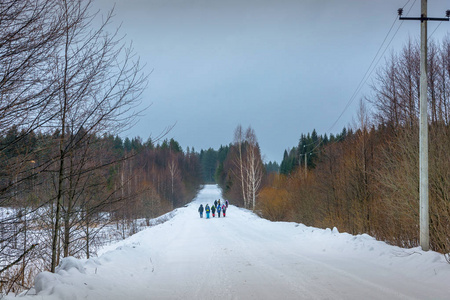 在冰雪覆盖的森林旅游的游客一小群