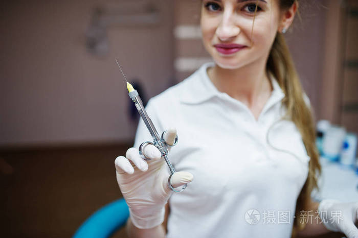 白大衣与注射器 f 合影的一名女牙医的肖像