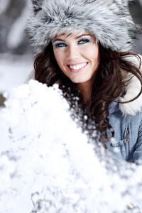 美丽的女人在玩雪
