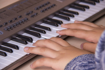 漂亮的女孩手打电子钢琴键盘