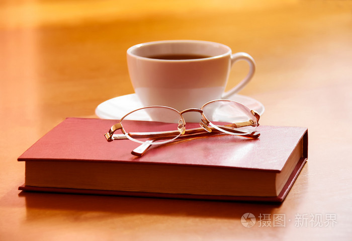 书, 眼镜和木制背景上茶