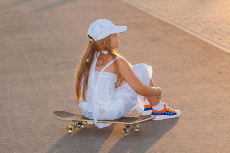 十几岁的女孩在晚上街上骑滑板