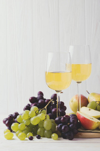 两杯白葡萄酒，新鲜的葡萄和梨