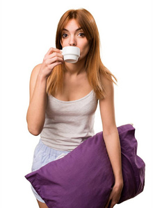 美丽的女孩穿着睡衣捧着一杯咖啡