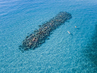 透明石头在沧海中反射的人：意大利湾海滩的清爽与对比