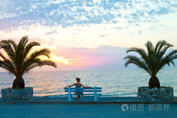 女性放松在海滩的长椅上