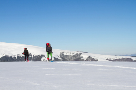 在山里徒步旅行带着背包和帐篷雪的冬天