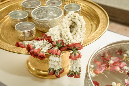 泰国花环花和茉莉花和玫瑰的花冠，金色托盘上的碗里的水