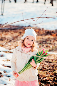 春天的郁金香花束上的走在阳光灿烂的日子快乐微笑的孩子女孩画像