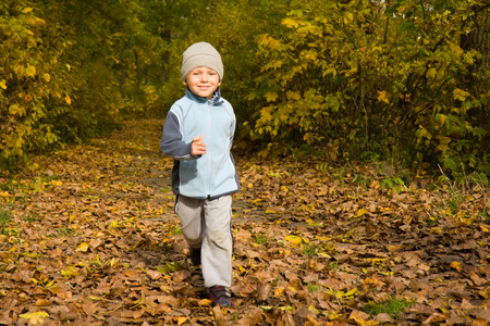 秋天的景色中奔跑的男孩图片