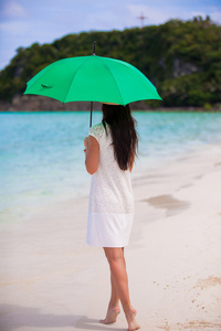 年轻的女孩，在白色的沙滩伞