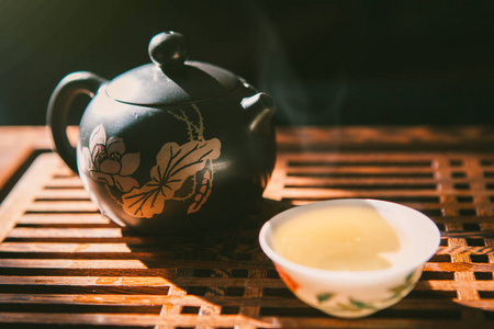 中国茶道。茶壶和绿色普洱茶与少量的蒸气的木桌子上一杯。亚洲的传统文化