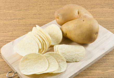 马铃薯和炸土豆片在木板上图片