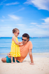 父亲和白色海滩上的小女儿
