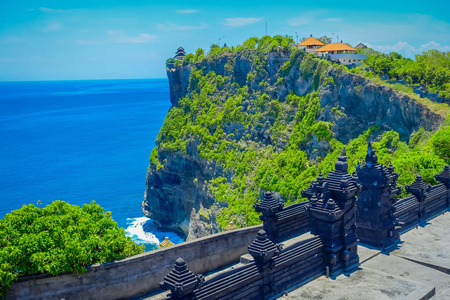 供游客参观令人惊异的乌鲁瓦图寺在巴厘岛，阳光明媚的日子