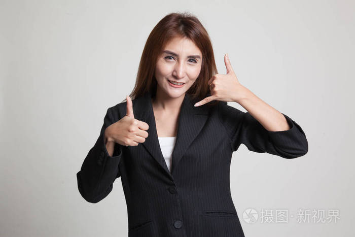 年轻的亚洲女人竖起大拇指显示手机的手势照片-正版商用图片00p3z7-摄