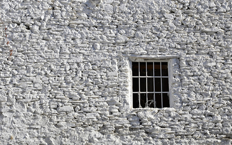 在白色的石头墙的旧窗口
