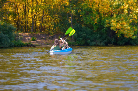 家庭的皮划艇 母亲和儿童在皮艇划上河独木舟之旅 活跃夏季周末和度假 体育和健身的概念