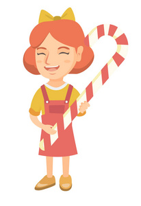 白种人的小女孩抱着圣诞糖果手杖