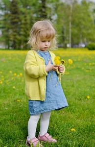 可爱的小女孩与蒲公英公园散步