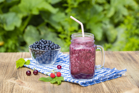 从蓝莓，树莓，樱桃和香蕉在玻璃杯子里的健康奶昔
