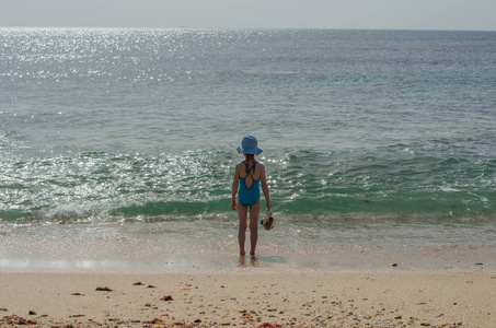 在泳装女孩站着，看在海洋