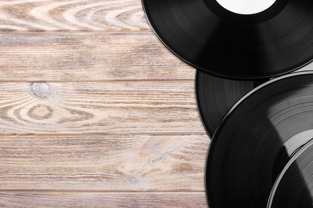 黑黑胶唱片在木桌上，与副本空间选择性焦点。顶视图