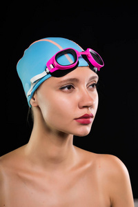 严重的女孩游泳帽和眼镜准备去游泳，游泳池