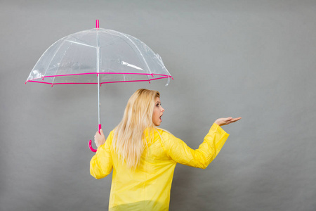 女人穿着雨衣打着伞检查天气图片