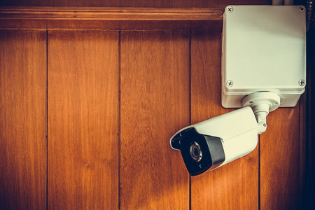 安全照相机或摄像机在房间里的木墙上
