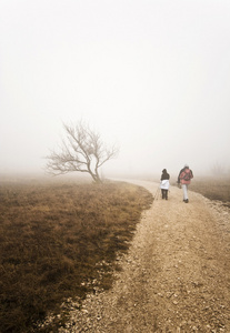 一对夫妇在恶劣天气下徒步上山图片