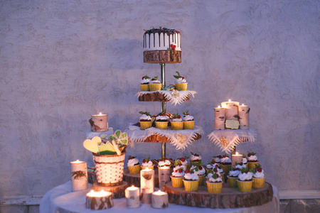 婚礼蛋糕和蜡烛在一个架子上，由木头制成的蛋糕