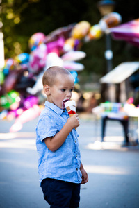夏季的一天在公园里吃冰激淋的一点男孩