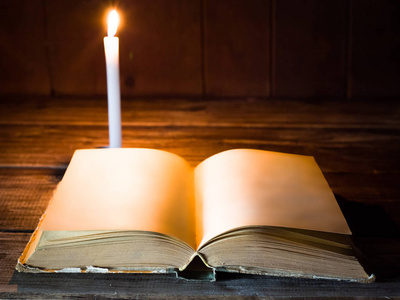 一本书打开空白页取决于燃烧蜡烛木桌那里